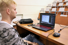 Asystent wykładowcy, korzystający z laptopa podczas zajęć zdalnych