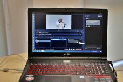 Laptop, na którym wyświetlana jest transmisja online