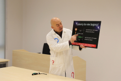 Prowadzący - Piotr Sołkiewicz prezentujący plakat: Lasery to nie bajery