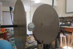 Dwa metalowe talerze, a po środku piłka owinięta folią aluminiową