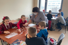dzieci pracujące w grupach i wykładowczyni