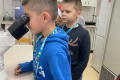 Chłopiec patrzący w mikroskop