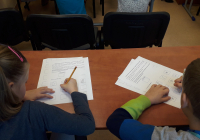 Dziewczynka i chłopczyk wypełniający karty pracy