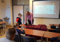 Prowadzący zajęcia wraz z dziećmi. W tle slajd  Rodzaje współczesnych aparatów