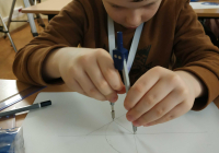 Chłopiec rysujący koło cyrklem