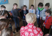 Dzieci i wykładowczyni grający w grę edukacyjną