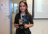 Dziewczynka trzyma zabytkowy aparata fotograficzny