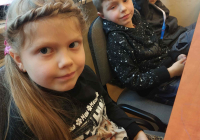 Dziewczynka i dwóch chłopców siedzących w ławce