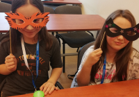 Dziewczynki pozujące z maskami wykonanymi z papieru