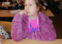 Dziewczynka w różowej bluzie  podczas zajęć