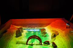 kuweta z pisakiem, na której wyświetlane są linie topograficzne oraz zabawki