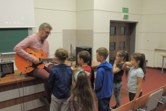dr Wojciech Lipiński  grający na gitarze i dzieci