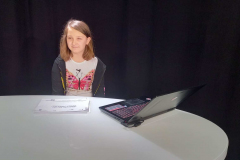 dziewczynka siedząca za stałem