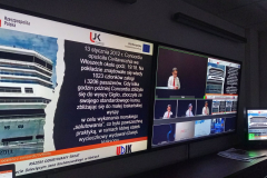 monitory w studiu UCM  wyświetlające prezentacje i prelegenta