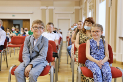 dzieci siedzące na rozdaniu dyplomów