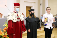 JM Rektor UJK prof. dr hab. Stanisław Głuszek, dr hab. Anna Wileczek, prof. UJK i chłopiec odbierający dyplom