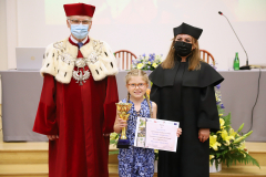 JM Rektor UJK prof. dr hab. Stanisław Głuszek, dr hab. Anna Wileczek, prof. UJK i dziewczynka odbierająca dyplom
