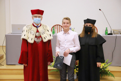 JM Rektor UJK prof. dr hab. Stanisław Głuszek, dr hab. Anna Wileczek, prof. UJK i chłopiec odbierający dyplom