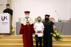 JM Rektor UJK prof. dr hab. Stanisław Głuszek, dr hab. Anna Wileczek, prof. UJK i chłopiec odbierający dyplom