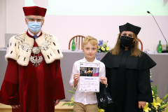 JM Rektor UJK prof. dr hab. Stanisław Głuszek, dr hab. Anna Wileczek, prof. UJK i chłopiec odbierający dyplom
