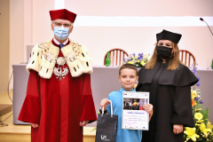 JM Rektor UJK prof. dr hab. Stanisław Głuszek, dr hab. Anna Wileczek, prof. UJK i chłopiec odbierający dyplom