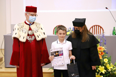JM Rektor UJK prof. dr hab. Stanisław Głuszek, dr hab. Anna Wileczek, prof. UJK i chłopiec odbierający dyplom