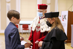 JM Rektor UJK prof. dr hab. Stanisław Głuszek, dr hab. Anna Wileczek, prof. UJK i chłopiec odbierający dyplom